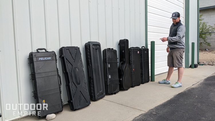 Man inspecting gun cases leaning against building
