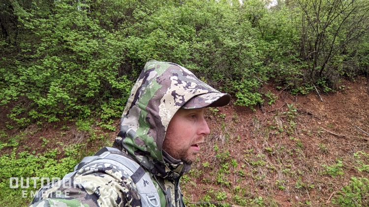 Hunter with camo jacket and hood on in rain