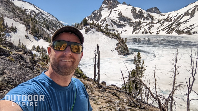 Man wearing smith deckboss sunglasses in front of frozen mountain lake