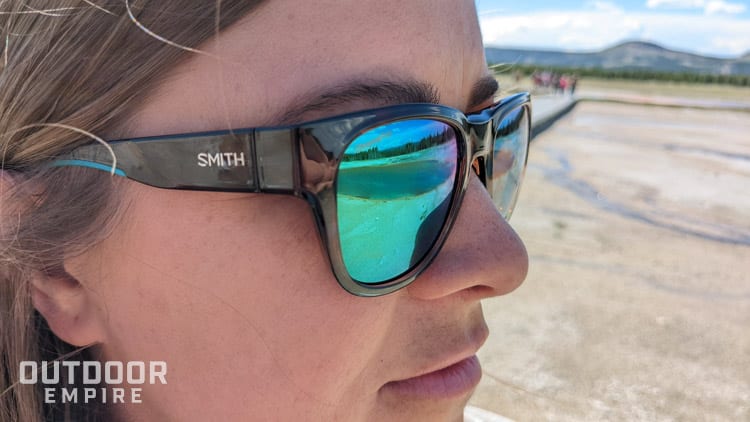 Reflection of hot spring in mirrored sunglasses on woman's face