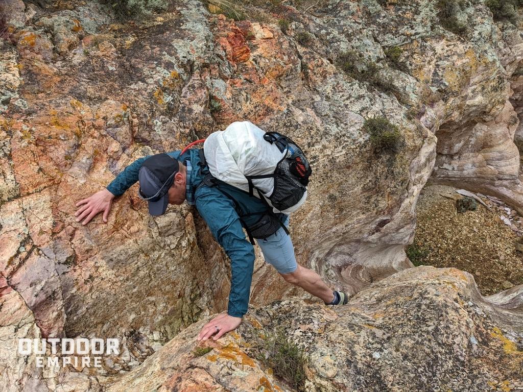 hiker scrambling up the Painted Canyon with Hyperlite Junction Ultralight Backpack
