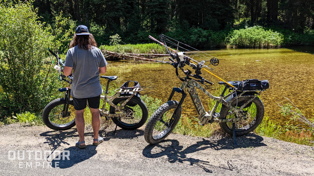 Man standing next to bikes by a stream