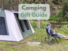 Camper on chair by tent and river