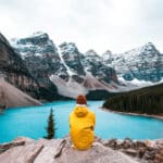 Woman sitting overlooking moraine lake and mountains