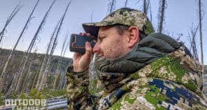 Hunter holding rangefinder to eye