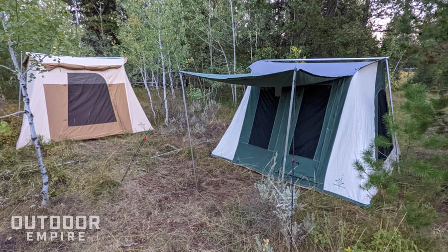 Two canvas tents setup next to each other in forest