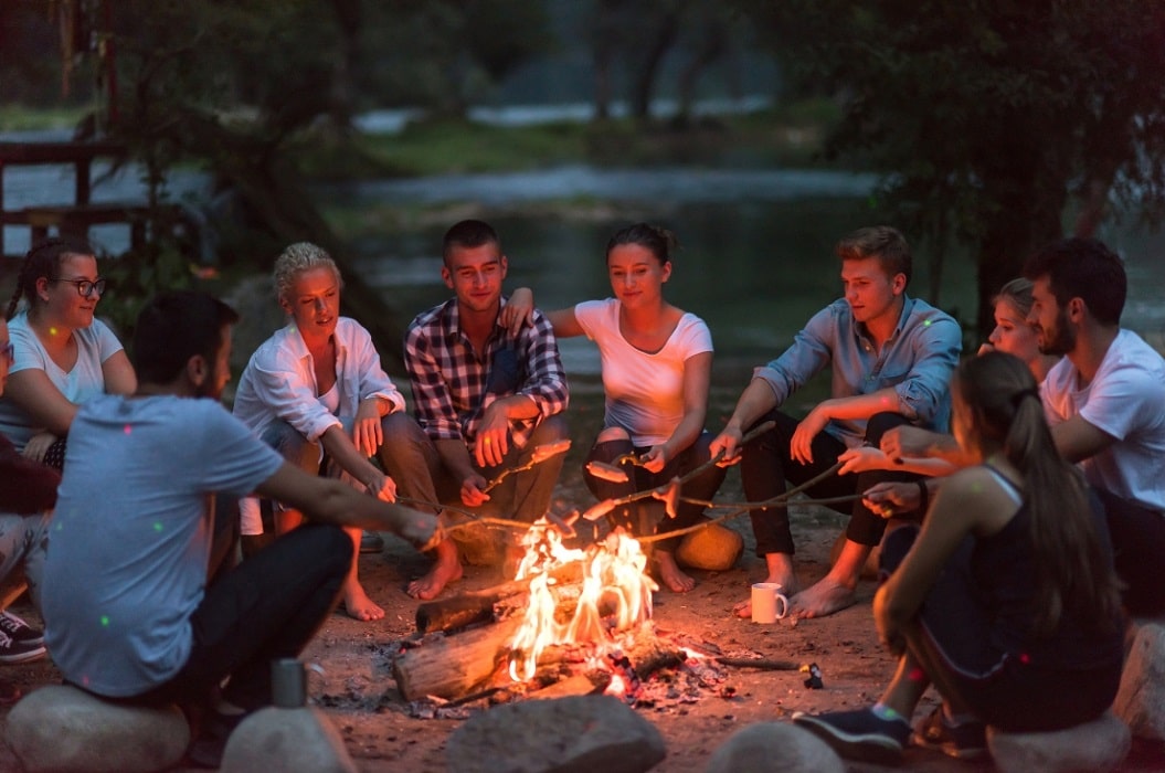 adults around a camp fire on a work retreat