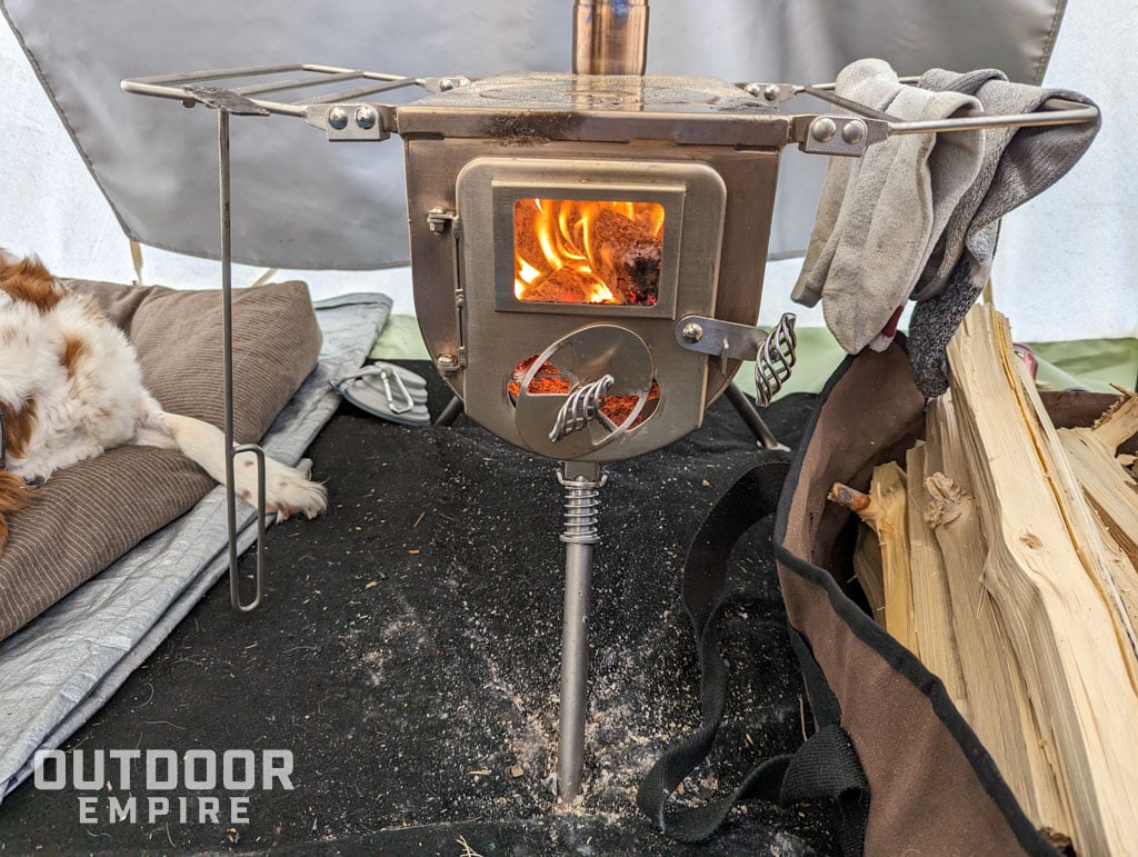 Tent stove with fire burning inside a hot tent