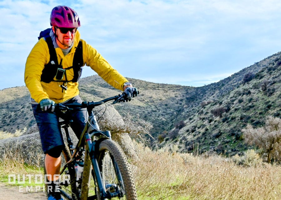 Mountain biker wearing rocky talkie 5 watt radio on vest on a trail