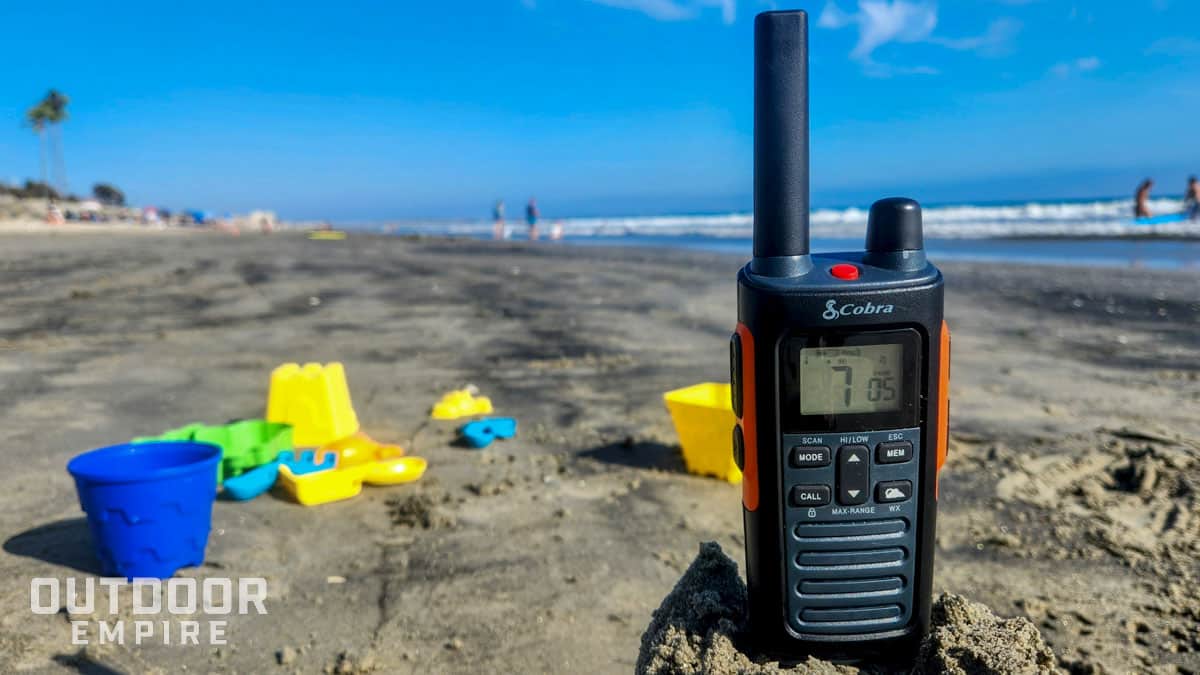 cobra rx680 walkie talkie sitting on sand by beach toys