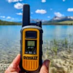 DeWalt DXFRS800 walkie talkie in hand with mountain lake in background