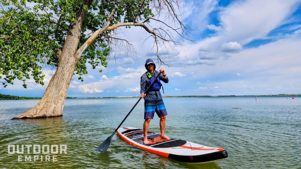 Man paddleboarding with waterproof walkie talkie on life vest