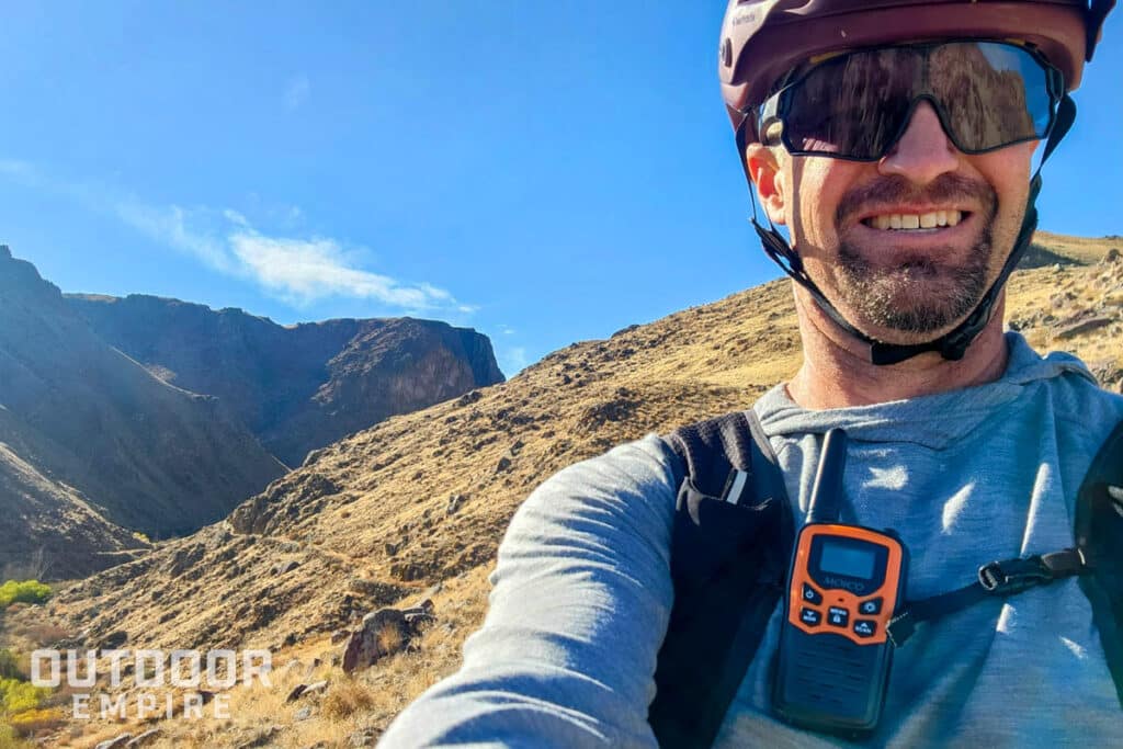 Alex marshall with moico walkie talkie clipped on chest strap while mountain biking
