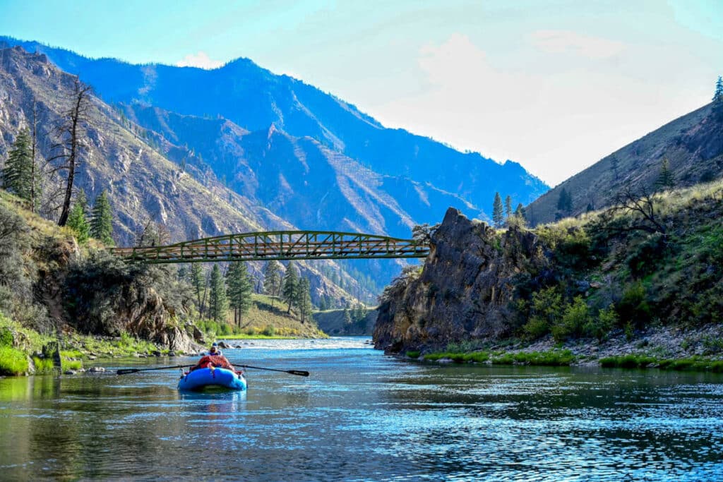 Whitewater raft on flat water on middle fork of salmon river with bridge just ahead