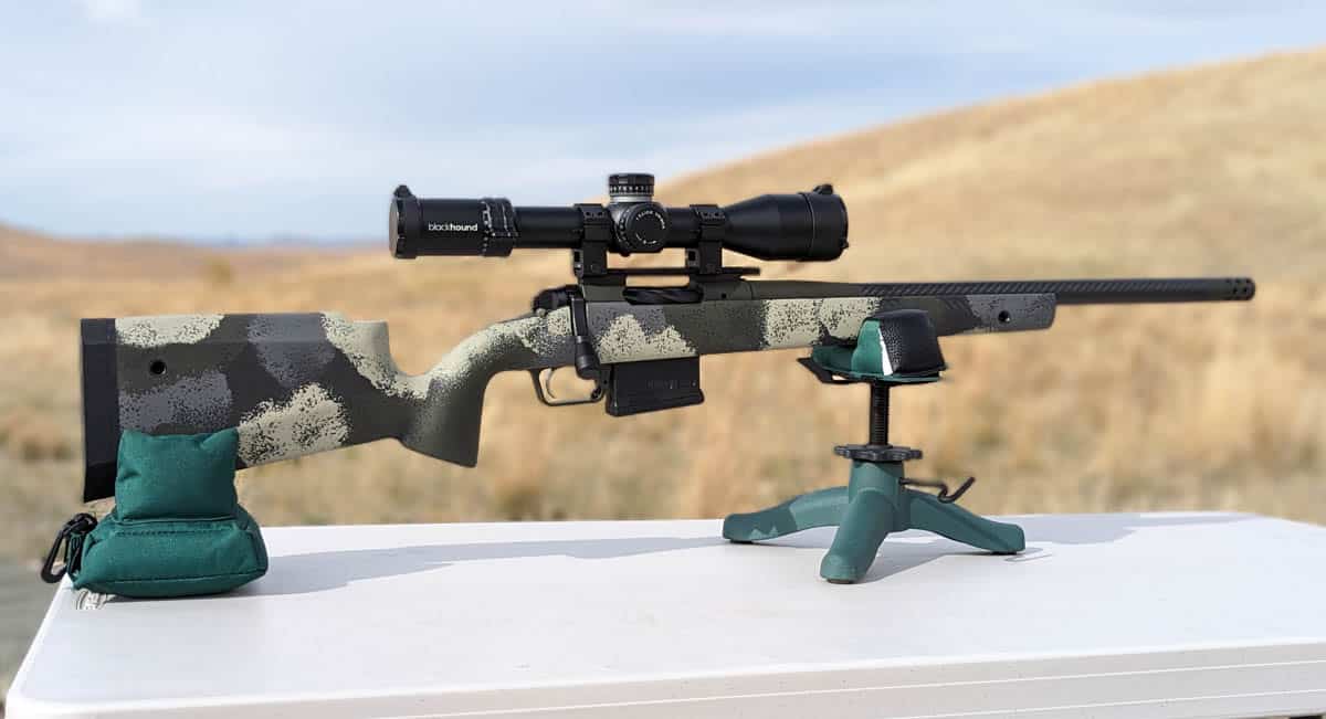 Hunting rifle sitting on a table on shooting rests