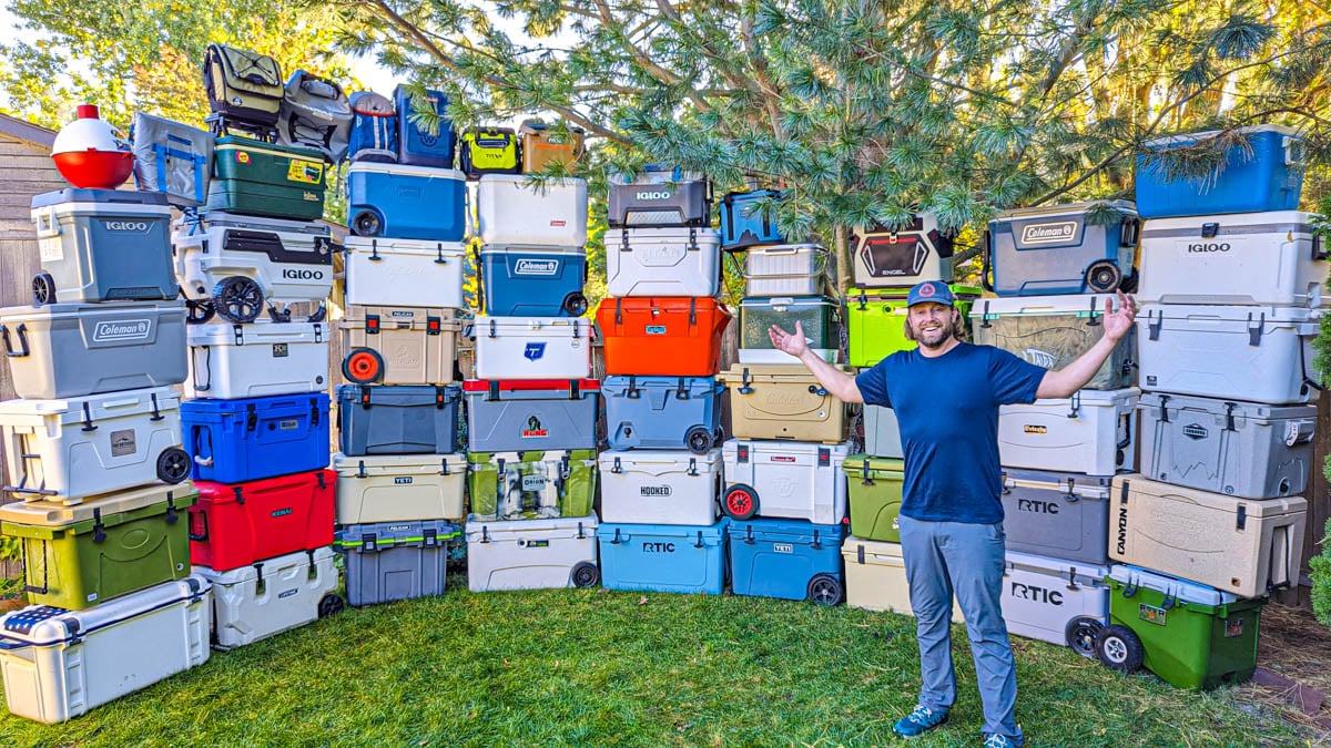 Man smiling with stacked wall of coolers behind him