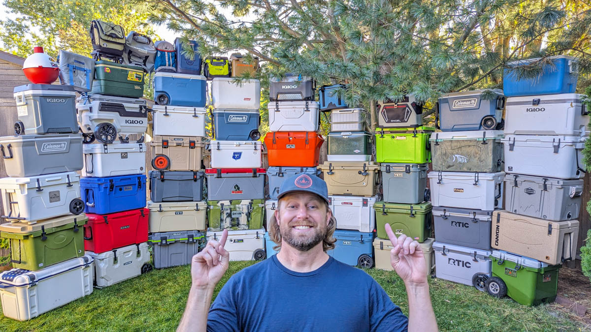 Man pointing behind him to a wall of stacked best coolers