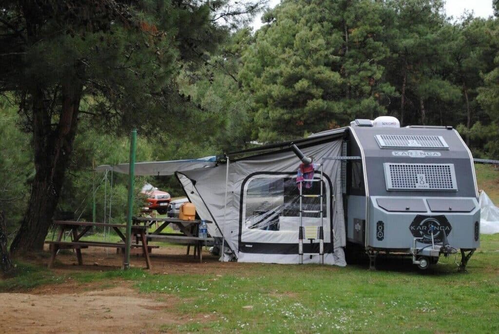 travel trailer at a campsite in a forest